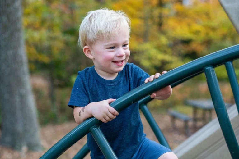 Jongetje speelt op een klimrek, leert vertrouwen op zijn lichaam.
