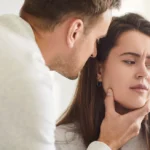 Man grijpt vrouw dreigend bij haar gezicht, symboliseert dat iemand moet herstellen na narcistische mishandeling