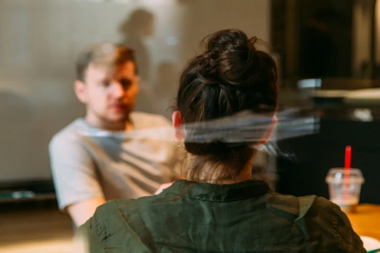 Man en vrouw in gesprek aan kantoortafel, symboliseert feedback ontvangen